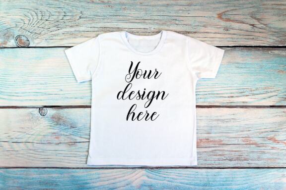 Kids White t-shirt Mockup bundle on a wooden background.