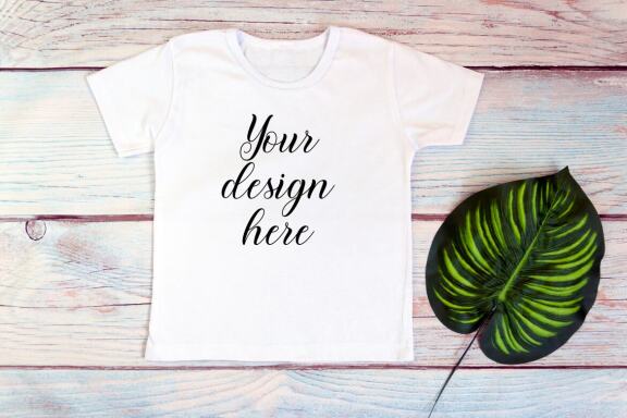 Kids White t-shirt Mockup bundle on a wooden background.