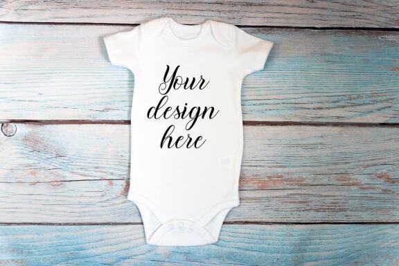 Baby Bodysuit mockup bundle with toys on a wooden background.  Kids T-shirt Mockup. 