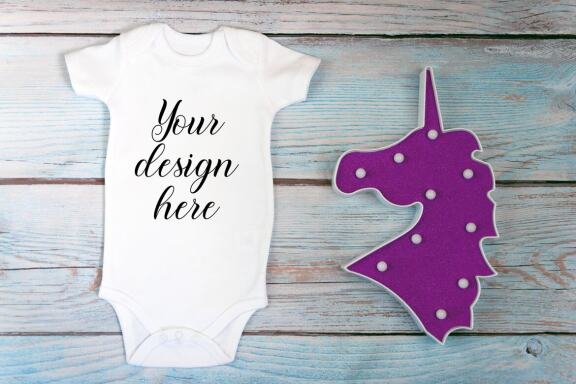 Baby Bodysuit mockup bundle with toys on a wooden background.  Kids T-shirt Mockup. 