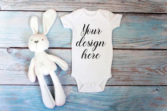 Baby Bodysuit mockup bundle with toys on a wooden background.  Kids T-shirt Mockup. 