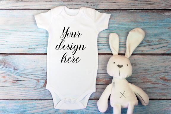Baby Bodysuit mockup bundle with toys on a wooden background.  Kids T-shirt Mockup. 