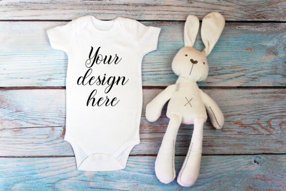 Baby Bodysuit mockup bundle with toys on a wooden background.  Kids T-shirt Mockup. 
