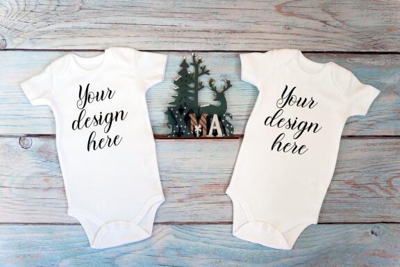 Christmas t-shirts and bodysuits mockups Bundle on a wooden background. Winter Christmas styled photo mockup.