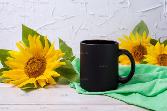 Black coffee mug mockup with green napkin and sunflowers.
