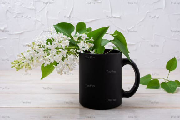 Black coffee mug mockup with blooming white lilac.